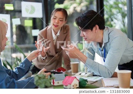 Sustainable Solutions and Team Collaboration. A group discussing eco-friendly building models and renewable energy concepts. 131883000