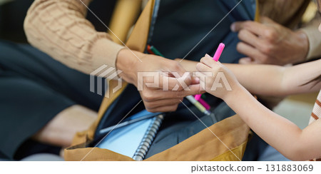 Organization and Support. A father helps his daughter gather school supplies in a backpack. 131883069