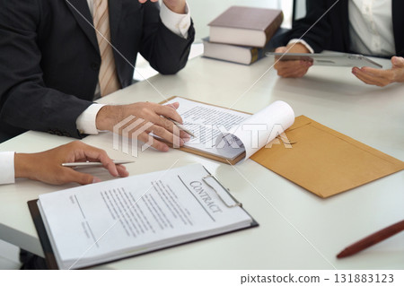 Contract Review and Legal Discussion. Legal professionals analyzing contract details and strategizing during a focused meeting. Contract Review and Legal Discussion. Legal professionals analyzing contract details and strategizing during a focused meeting. 131883123