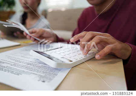 Budgeting and Financial Planning. A person calculating expenses using a calculator for effective financial management. Budgeting and Financial Planning. A person calculating expenses using a calculator for effective financial management. 131883124