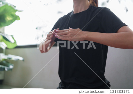 Mindfulness and Relaxation. A woman practicing mindfulness with hands raised, focusing on her well-being. 131883171