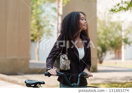 Sustainable Transportation and Eco-Friendly Lifestyle. A woman with a bicycle enjoying the outdoors, promoting green commuting. Sustainable Transportation and Eco-Friendly Lifestyle. A woman with a bicycle enjoying the outdoors, promoting green commuting. 131883374