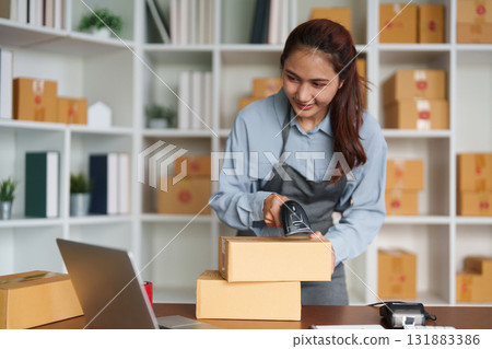 E-commerce and Fulfillment. A young entrepreneur scanning packages in her workspace. 131883386