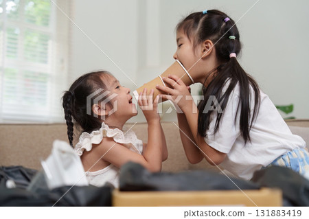 Imaginative Play and Recycling. Two girls creatively using paper cups as fun props during a play session focused on eco-friendliness. Imaginative Play and Recycling. Two girls creatively using paper cups as fun props during a play session focused on eco-friendliness. 131883419
