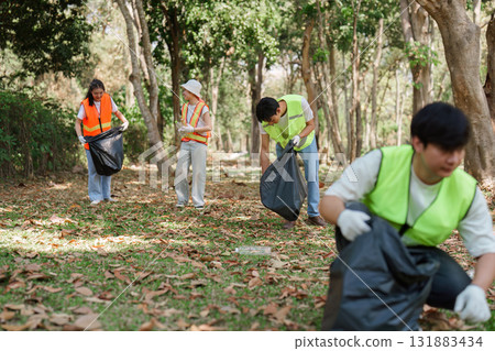 Teamwork and Community Engagement. Volunteers gathering waste to enhance the beauty of a local park. 131883434