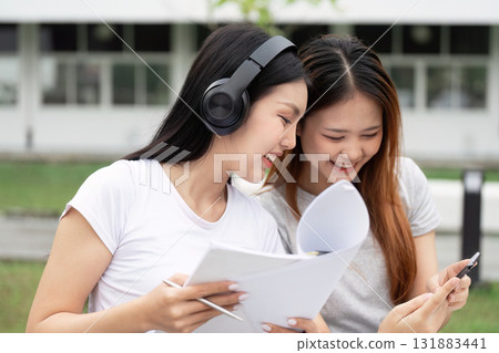 Study Buddies and Education. Two students engaged in collaborative learning, sharing insights and resources while enjoying their study session. 131883441