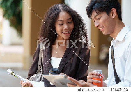 Sustainable Innovations and Productive Collaboration. A woman sharing notes with a man in an eco-friendly setting, emphasizing teamwork for a better future. 131883450