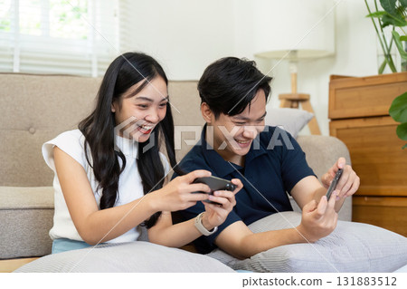 Gaming and Friendship. Two friends bonding over video games, sharing excitement and joy while playing together at home. Gaming and Friendship. Two friends bonding over video games, sharing excitement and joy while playing together at home. 131883512