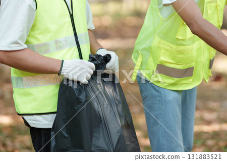 Active participation. Volunteers engaging in garbage collection for a cleaner future. Active participation. Volunteers engaging in garbage collection for a cleaner future. 131883521