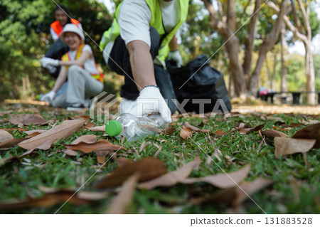 Environmental Responsibility. A volunteer collects plastic waste as part of a community effort to promote sustainability and a cleaner habitat. 131883528