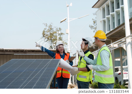 Renewable energy teamwork. Engineers discussing installation strategies at a solar power site. Renewable energy teamwork. Engineers discussing installation strategies at a solar power site. 131883544