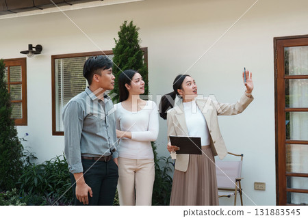 Real estate showing. A real estate agent presenting a property to clients, illustrating home features and engagement. 131883545