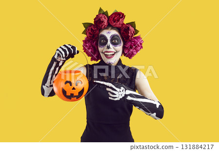 Cheerful woman in Halloween Mexican costume hints with gesture that she wants to trick or treat. Cheerful woman in Halloween Mexican costume hints with gesture that she wants to trick or treat. 131884217