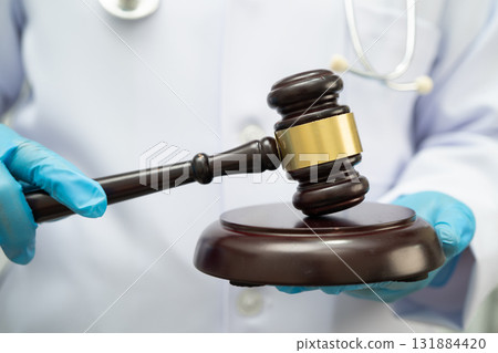 Doctor holding judge gavel, forensic medicine, medical law and crime justice. 131884420