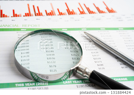 Magnifying glass on spreadsheet and graph paper. Financial data economy, Business. 131884424