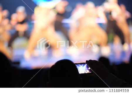 A man records a video of a concert on his mobile phone. High quality photo 131884559