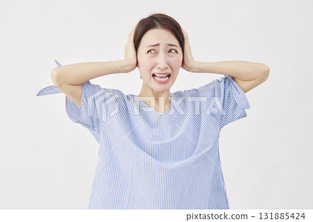 Woman, middle-aged, covering her ears, white background Woman, middle-aged, covering her ears, white background 131885424