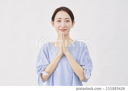 Woman, middle-aged, praying, hands together, looking at camera, white background 131885426