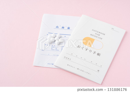 粉紅色背景的醫學筆記本和藥物 131886176