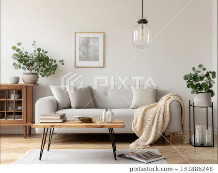 Cozy neutral living room sofa coffee table throw blanket potted plant pendant light minimalist framed art 131886248