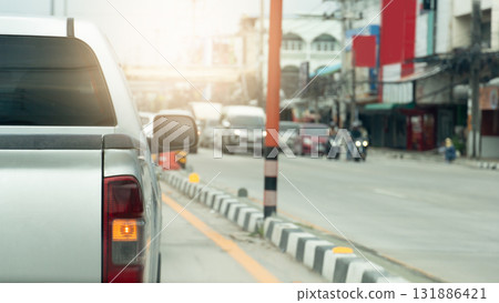 Rear side of pickup car with turn on right signal. Median strip painted in a mysterious White and black color. Opposite road with cars prepare to drive after green light open. Environment in the city, 131886421