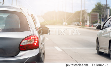 Rear side of mini car grey color with turn on brake light. Prepare to drive on the cement road. The road ahead is clear. With white line on the cement road. Rear side of mini car grey color with turn on brake light. Prepare to drive on the cement road. The road ahead is clear. With white line on the cement road. 131886423