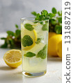 Refreshing lemonade with lemon slice mint leaf ice and sparkling water served in tall glass garnished with fresh mint sprig, bright citrus beverage with bubbly texture and summer mood 131887219