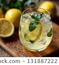 Refreshing lemonade with lemon slice, ice and mint garnish in glass on wooden board, bright citrus drink with fresh ingredients and cool summer vibe 131887222