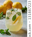 Refreshing lemon mint lemonade with ice and sparkling water, chilled glass garnished with lemon slice and fresh mint leaf, bright citrus beverage perfect for summer refreshment 131887223