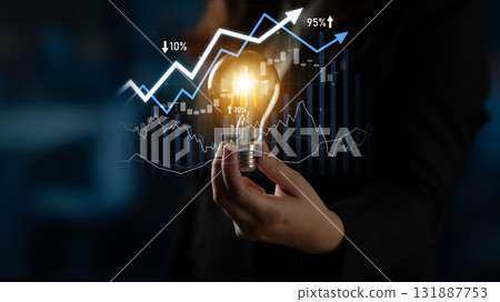Businesswoman Holding Light Bulb with Financial Graphs and Growth Arrows Representing Innovation and Investment Strategies for Success Scalp Businesswoman Holding Light Bulb with Financial Graphs and Growth Arrows Representing Innovation and Investment Strategies for Success Scalp 131887753