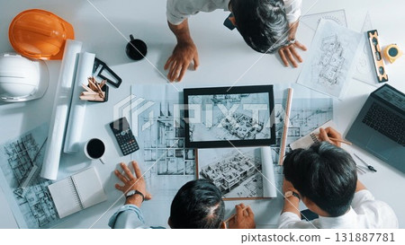 Top view of manager looking at plan while designer hold blueprint. Alimentation. Top view of manager looking at plan while designer hold blueprint. Alimentation. 131887781