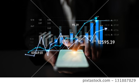 Business person analyzing financial data with glowing graphs and charts on mobile screen in dark office environment, showing growth and investment trends Scalp 131887829