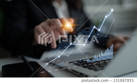 Person Analyzing Financial Data with Laptop and Graphs for Market Research and Business Growth in Modern Office Setting Scalp 131887855