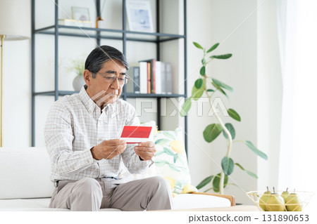 老人在客廳看存摺 131890653