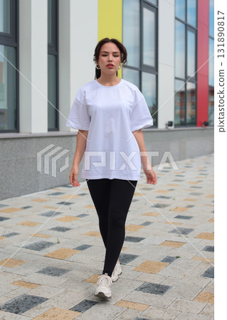 A Stylish and Fashionable Young Woman Dressed in a Casual Outfit, Enjoying the Outdoors 131890817