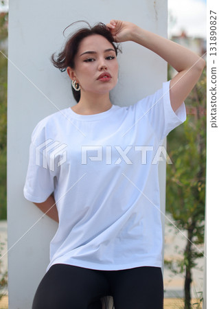 A Fashionable Young Woman is seen wearing a Casual White TShirt with style and flair A Fashionable Young Woman is seen wearing a Casual White TShirt with style and flair 131890827