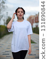 A Stylish Young Woman Dressed in an Oversized White TShirt and Comfortable Leggings 131890844