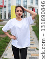 A Stylish and Fashionable Young Woman Dressed in a Casual Outfit, Enjoying the Outdoors 131890846