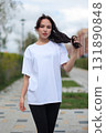 A Stylish Young Woman Dressed in an Oversized White TShirt and Comfortable Leggings 131890848