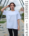A Stylish Young Woman Dressed in an Oversized White TShirt and Comfortable Leggings 131890851