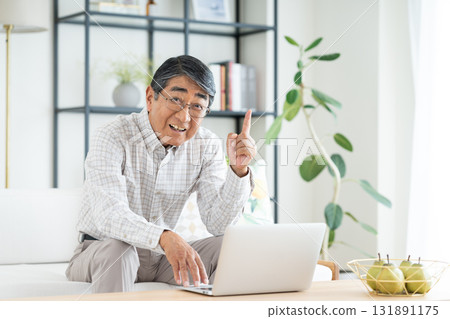 Senior man using a computer in the living room 131891175
