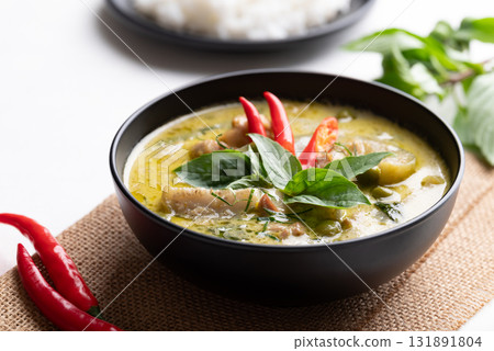 Thai green curry chicken in black bowl with rice and ingredients 131891804
