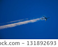 A Boeing passenger plane flying while leaving a contrail behind 131892693