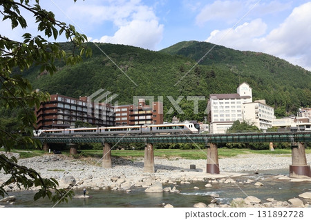 飛騨特快列車穿過 JR 高山本線下呂站附近的一座鐵路橋。 飛騨特快列車穿過 JR 高山本線下呂站附近的一座鐵路橋。 131892728