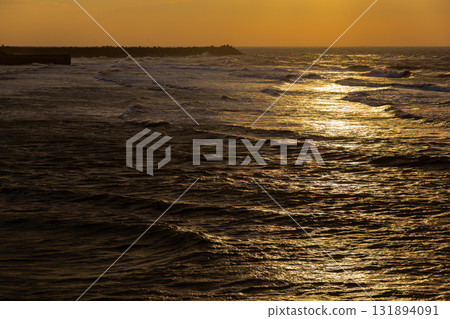 海岸線在金黃色餘暉中的寧靜與壯闊 海岸線在金黃色餘暉中的寧靜與壯闊 131894091