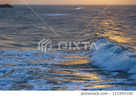 The tranquility and grandeur of the coastline in the golden afterglow 131894100