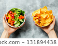 Unhealthy vs healthy food. vegetable salad and potato in different hands on green background . Choice between fast foods and vegetables, fruit. 131894438