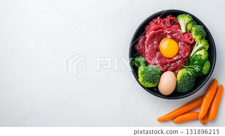 Raw beef, egg yolk, broccoli, and carrots on black plate. Species-specific pet food concept Raw beef, egg yolk, broccoli, and carrots on black plate. Species-specific pet food concept 131896215