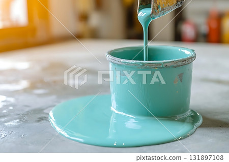 Fresh turquoise paint pouring from can onto wooden surface in artistic home renovation setting 131897108
