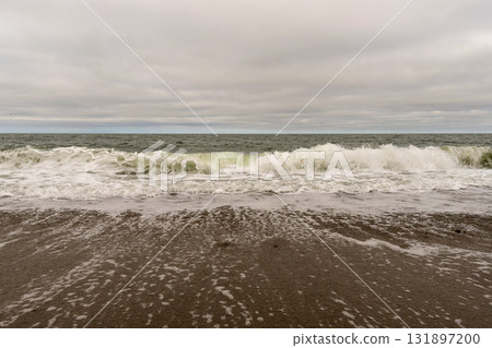 Powerful ocean wave crashing on sandy beach shoreline Powerful ocean wave crashing on sandy beach shoreline 131897200